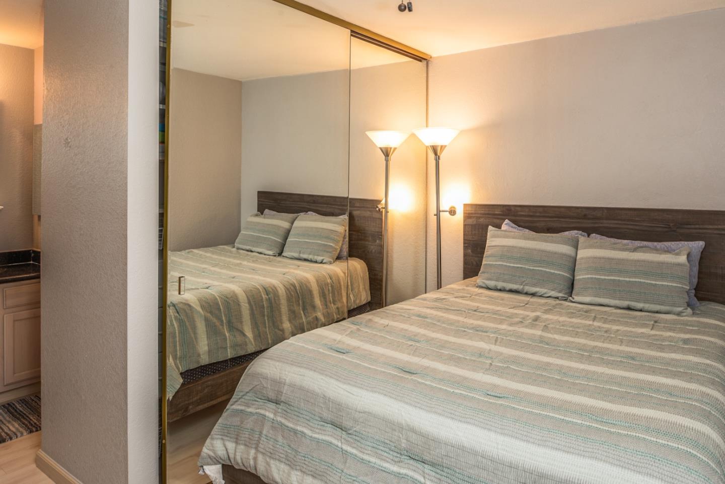 1 Surf Way, Unit 225 Monterey, CA 93940 - Photo 13 of 32 a bedroom with two bed and a night stand