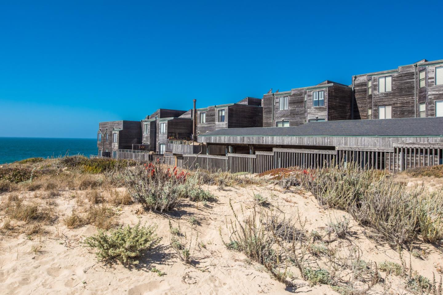 1 Surf Way, Unit 225 Monterey, CA 93940 - Photo 25 of 32 a building view with large trees and covered with wooden fence