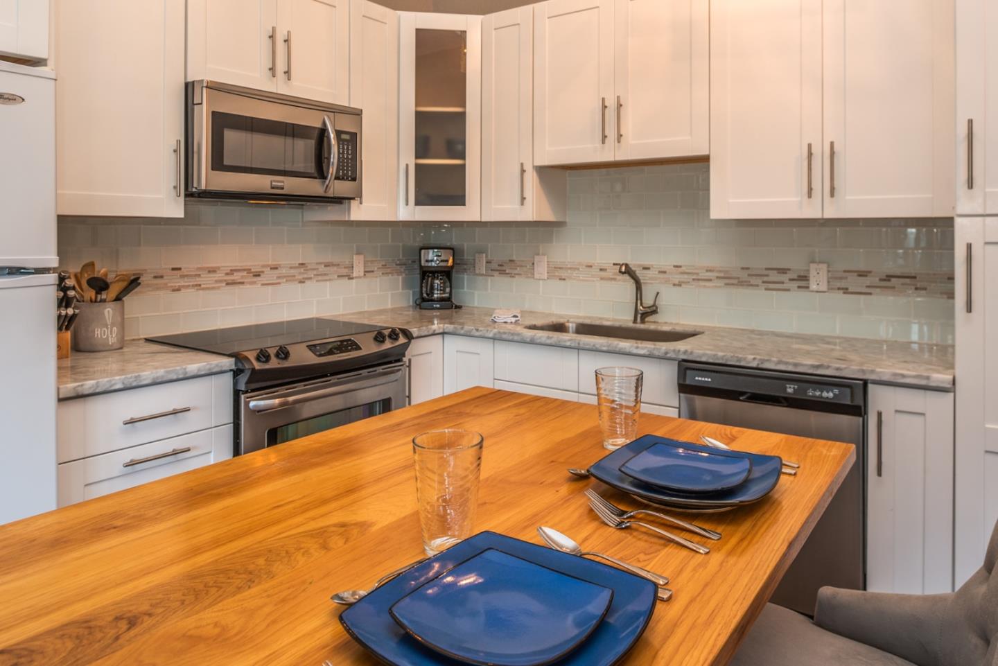 1 Surf Way, Unit 225 Monterey, CA 93940 - Photo 10 of 32 a kitchen with stainless steel appliances granite countertop a stove a sink and a microwave