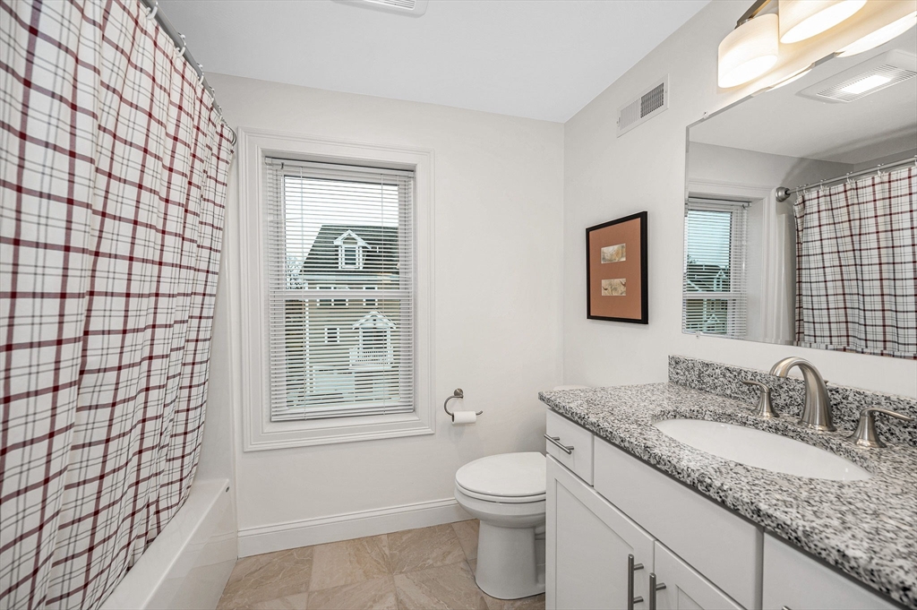 154 Chestnut Street, Unit 9 Lowell, MA 01852 - Photo 13 of 39 a bathroom with a granite countertop sink toilet and mirror