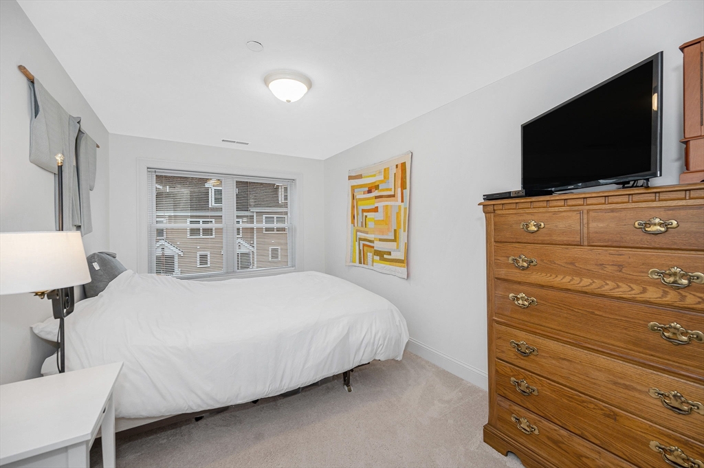 154 Chestnut Street, Unit 9 Lowell, MA 01852 - Photo 16 of 39 a bedroom with a bed and a flat screen tv