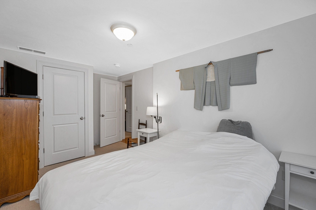 154 Chestnut Street, Unit 9 Lowell, MA 01852 - Photo 17 of 39 a bedroom with a bed and a flat screen tv