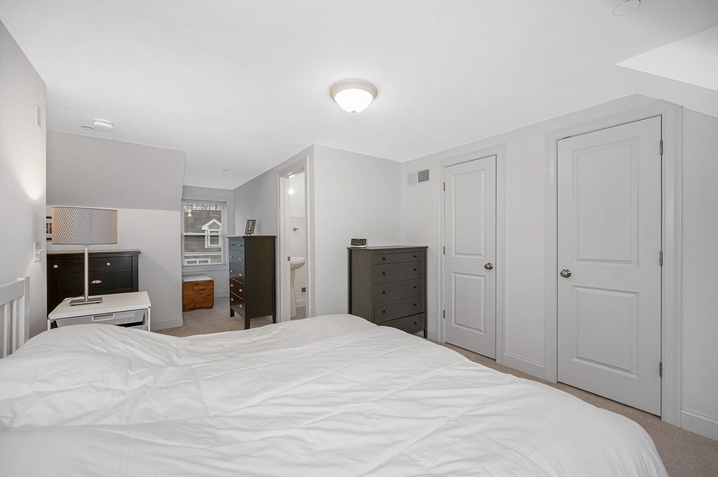 154 Chestnut Street, Unit 9 Lowell, MA 01852 - Photo 23 of 39 a bedroom with a large bed and dresser