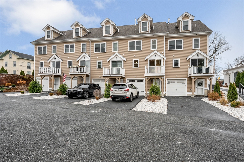154 Chestnut Street, Unit 9 Lowell, MA 01852 - Photo 28 of 39 a view of a big house with large windows and a cars parked in front of it