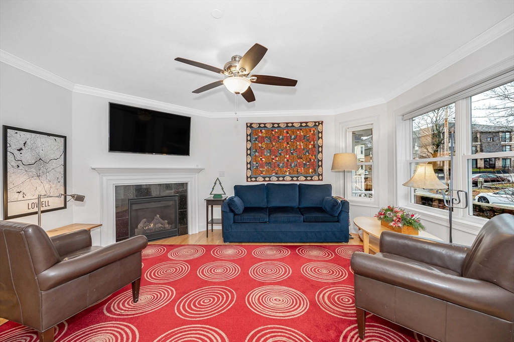 154 Chestnut Street, Unit 9 Lowell, MA 01852 - Photo 3 of 39 a living room with a couch a fireplace and a flat screen tv