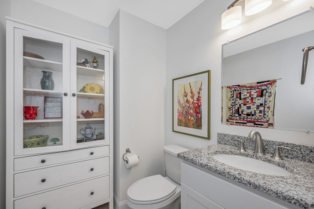 154 Chestnut Street, Unit 9 Lowell, MA 01852 - Photo 6 of 39 a bathroom with a granite countertop toilet sink and mirror