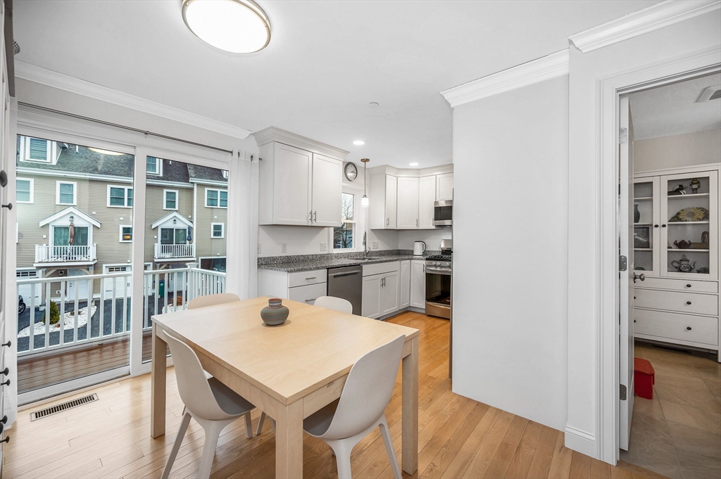 154 Chestnut Street, Unit 9 Lowell, MA 01852 - Photo 7 of 39 a kitchen with a table and chairs in it