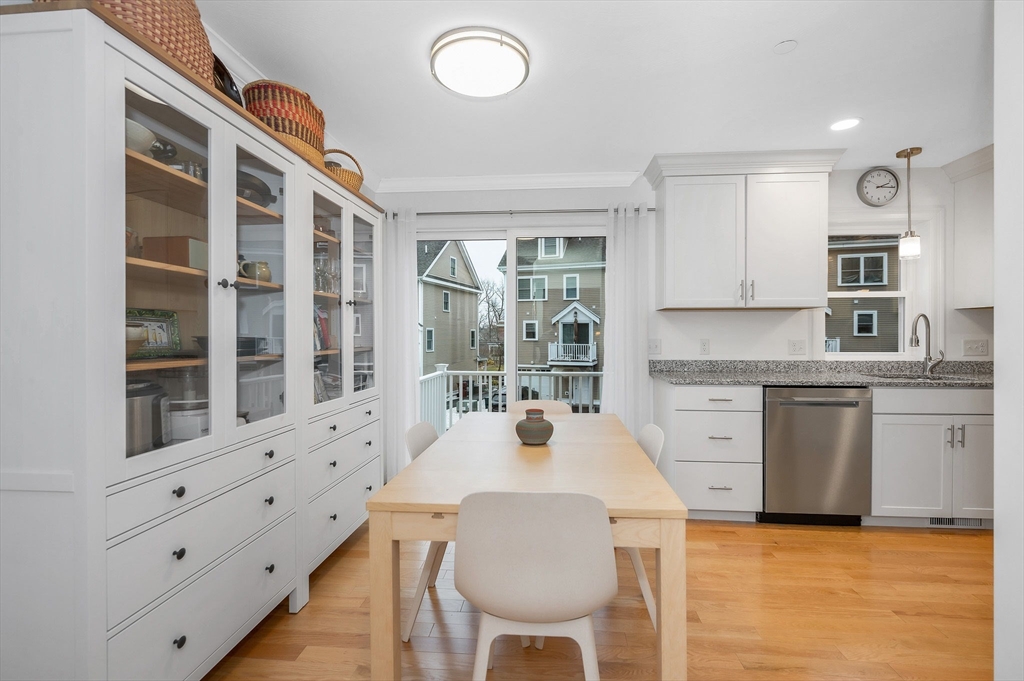 154 Chestnut Street, Unit 9 Lowell, MA 01852 - Photo 8 of 39 a kitchen with granite countertop a stove a sink a dining table and chairs