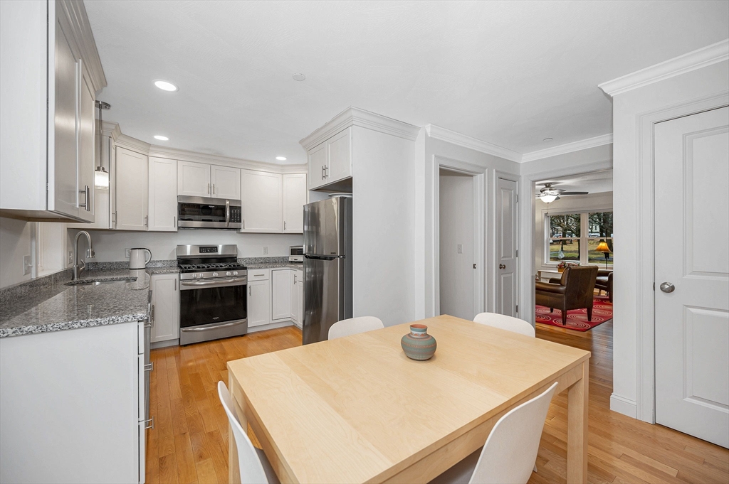 154 Chestnut Street, Unit 9 Lowell, MA 01852 - Photo 10 of 39 a kitchen with stainless steel appliances granite countertop a refrigerator a stove top oven a sink dishwasher and white cabinets with wooden floor