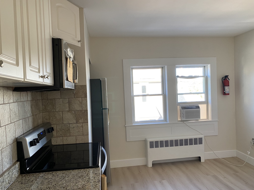 18 Highland Terrace, Unit 18 Needham, MA 02494 - Photo 4 of 14 a view of an empty room with wooden floor and a window