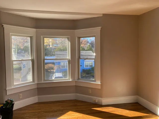 a view of a room with wooden floor and a window