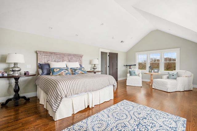 a view of a white house with a big yard and potted plants