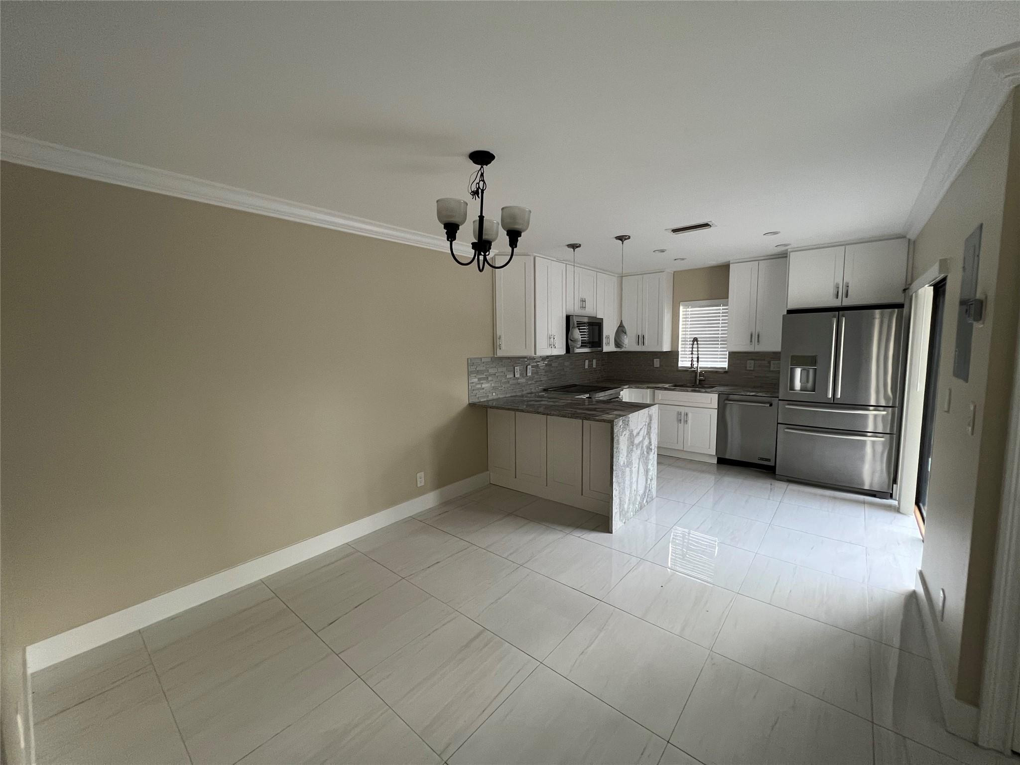 9380 Southwest 61st Way, Unit C Boca Raton, FL 33428 - Photo 2 of 32 a kitchen with granite countertop a sink cabinets and stainless steel appliances
