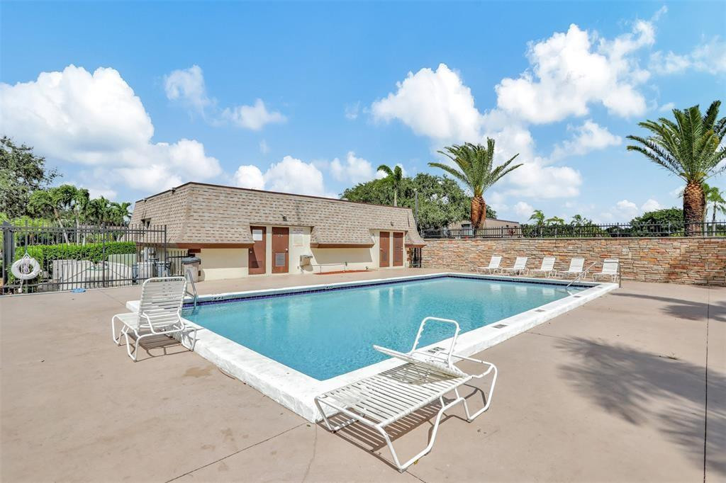 9380 Southwest 61st Way, Unit C Boca Raton, FL 33428 - Photo 26 of 32 a view of a swimming pool with a lounge chairs