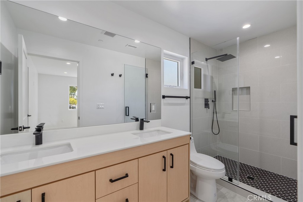 7437 Ranchito Avenue Van Nuys, CA 91405 - Photo 4 of 9 a bathroom with a sink a toilet and shower