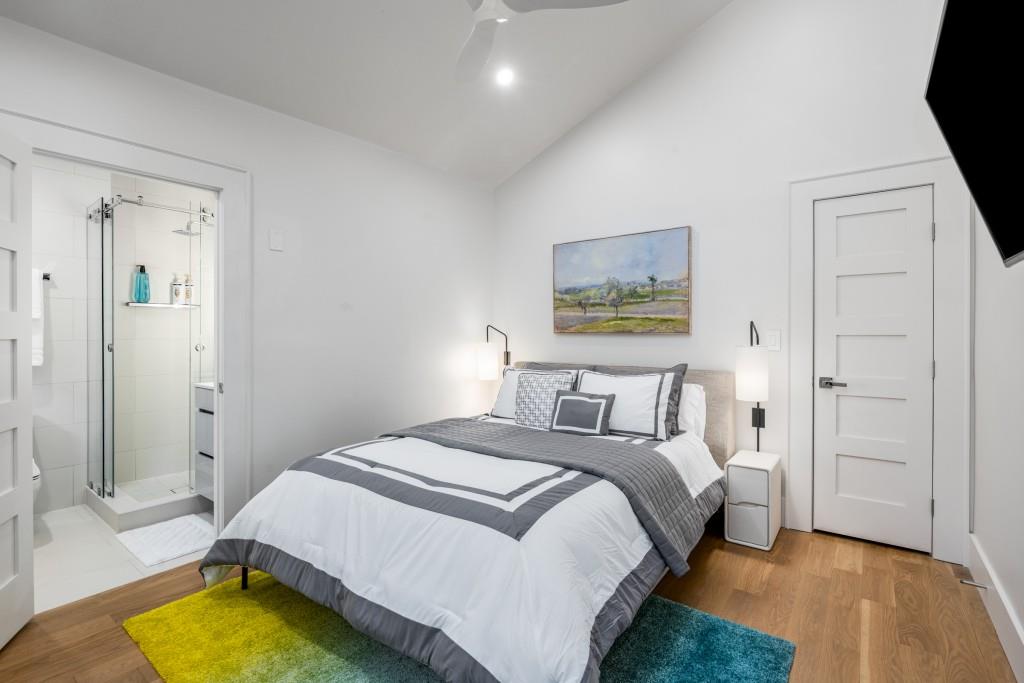 413 8th Street Northeast, Unit A Atlanta, GA 30309 - Photo 14 of 31 a bedroom with a bed a couch and a chandelier