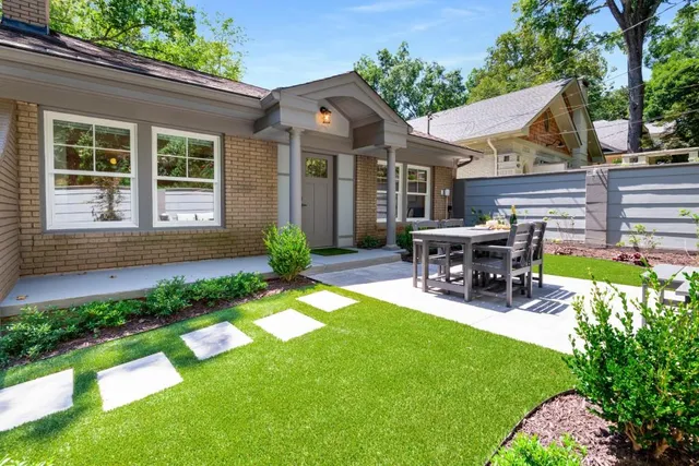a view of a house with patio and a yard