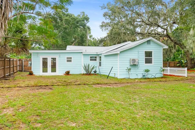 a white house that has a tree in front of it