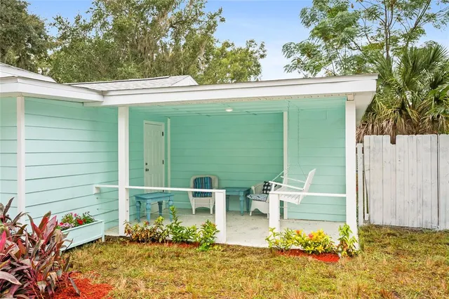 a balcony with table and chairs and potted plants