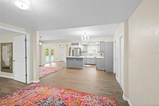 a open kitchen with white cabinets and wooden floor