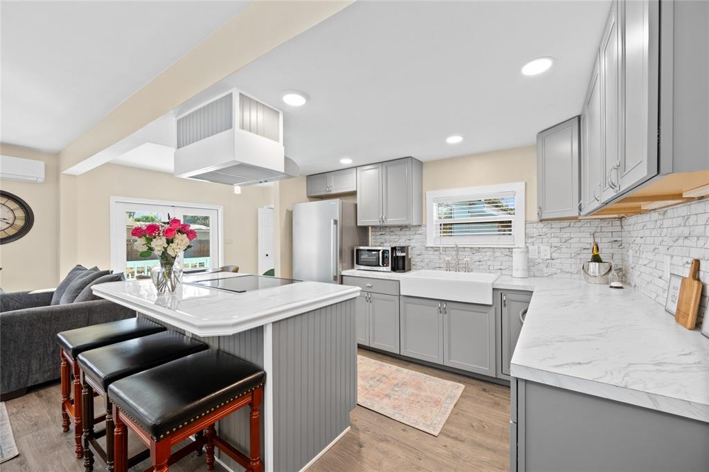 245 South Rhodes Street Mount Dora, FL 32757 - Photo 9 of 64 a kitchen with a dining table chairs sink and white cabinets