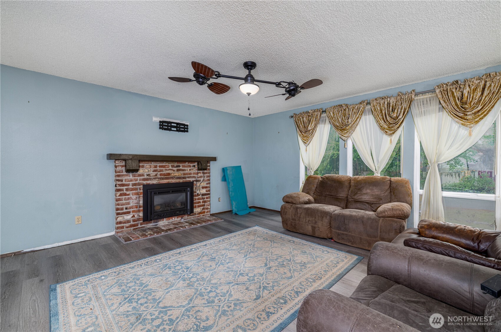 5189 Brasch Road Southeast Port Orchard, WA 98367 - Photo 3 of 24 a living room with furniture a fireplace and a large window