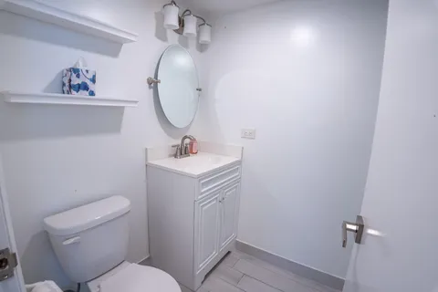 a bathroom with a toilet sink and mirror