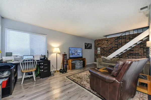a living room with furniture a wooden floor and next to a window