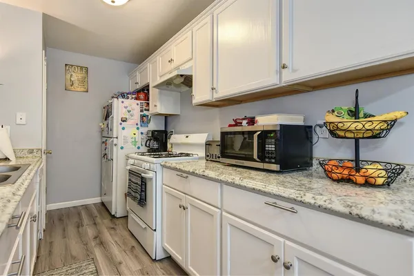 a kitchen with stainless steel appliances granite countertop a sink stove and cabinets