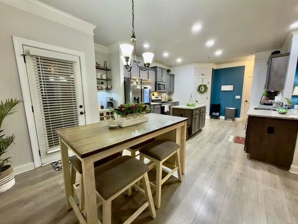 a kitchen with a stove a sink a kitchen island with wooden cabinets and floor