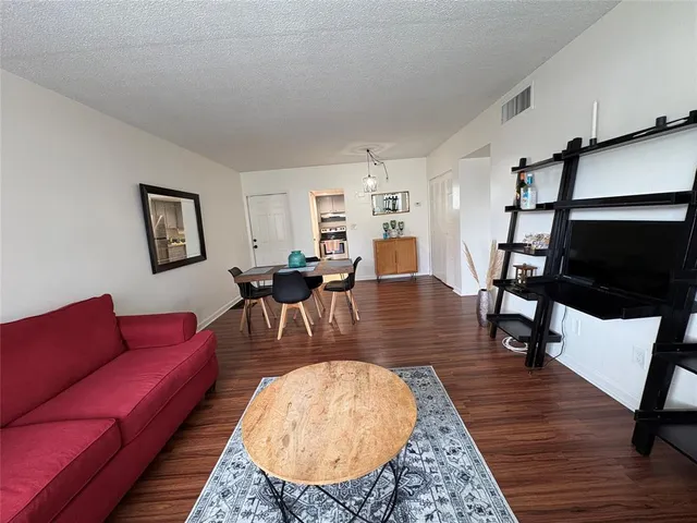 a living room with furniture a dining table and wooden floor
