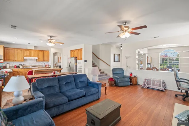 a living room with furniture kitchen view and a large window