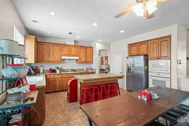 a kitchen with stainless steel appliances granite countertop a refrigerator sink stove microwave and cabinets