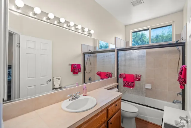 a bathroom with a sink vanity mirror and toilet