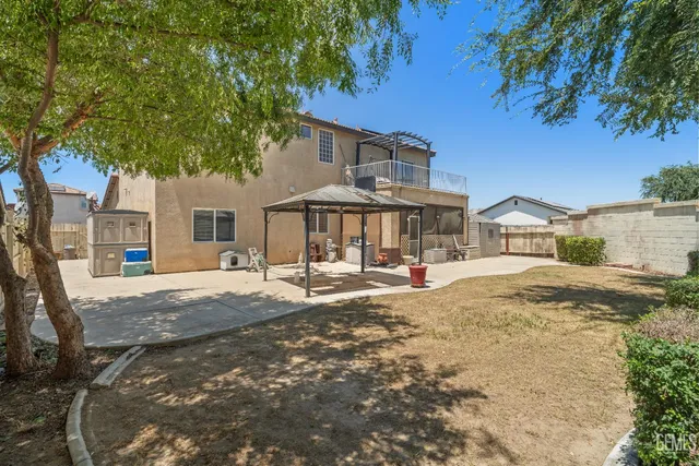 a front view of a house with a yard and large trees