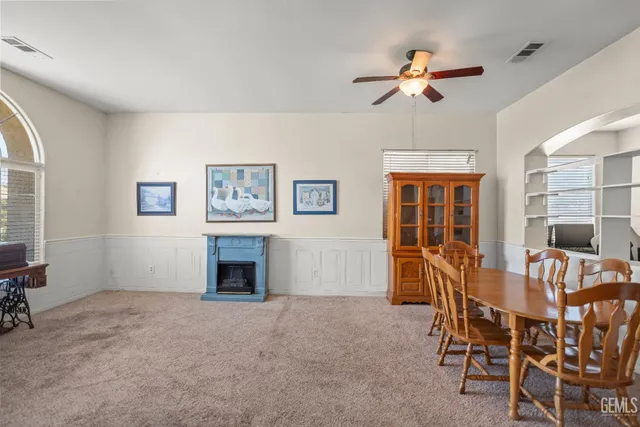 a dining room with furniture and chandelier fan