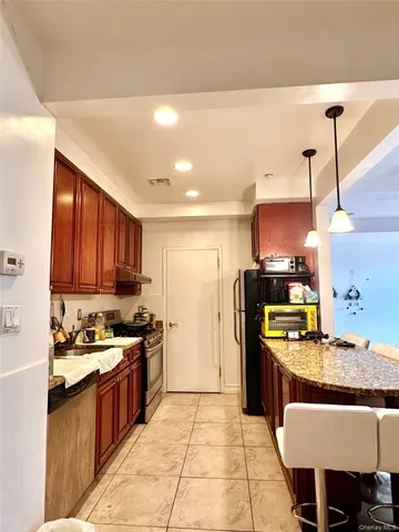 a kitchen with kitchen island granite countertop a sink window and cabinets