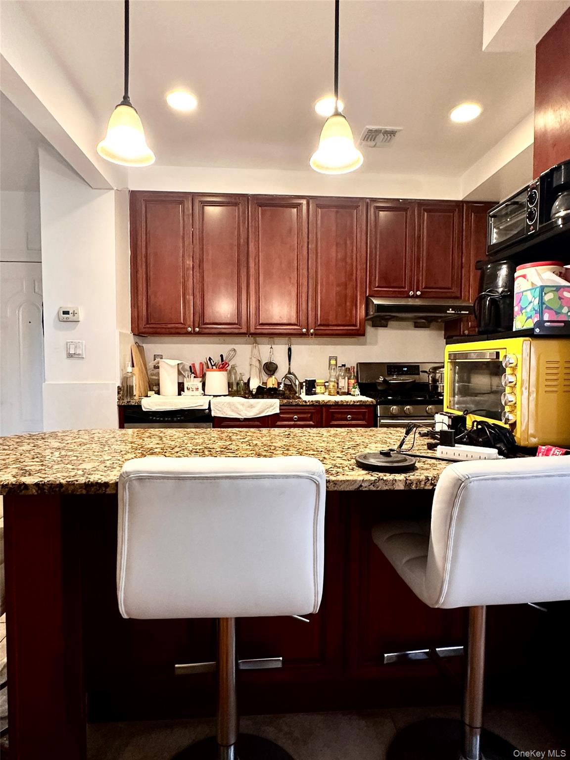 107-16 37th Avenue, Unit 4B Queens, NY 11368 - Photo 4 of 13 a kitchen with kitchen island granite countertop a sink window and cabinets