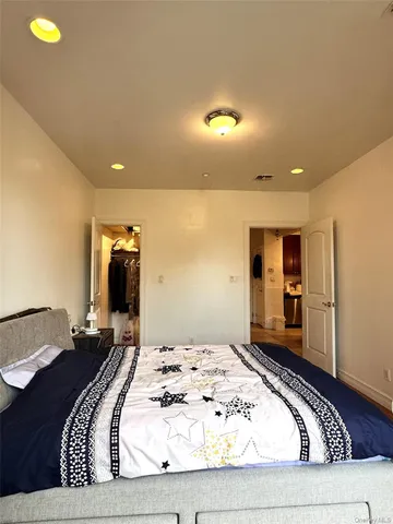 a spacious bedroom with a bed and wooden floor