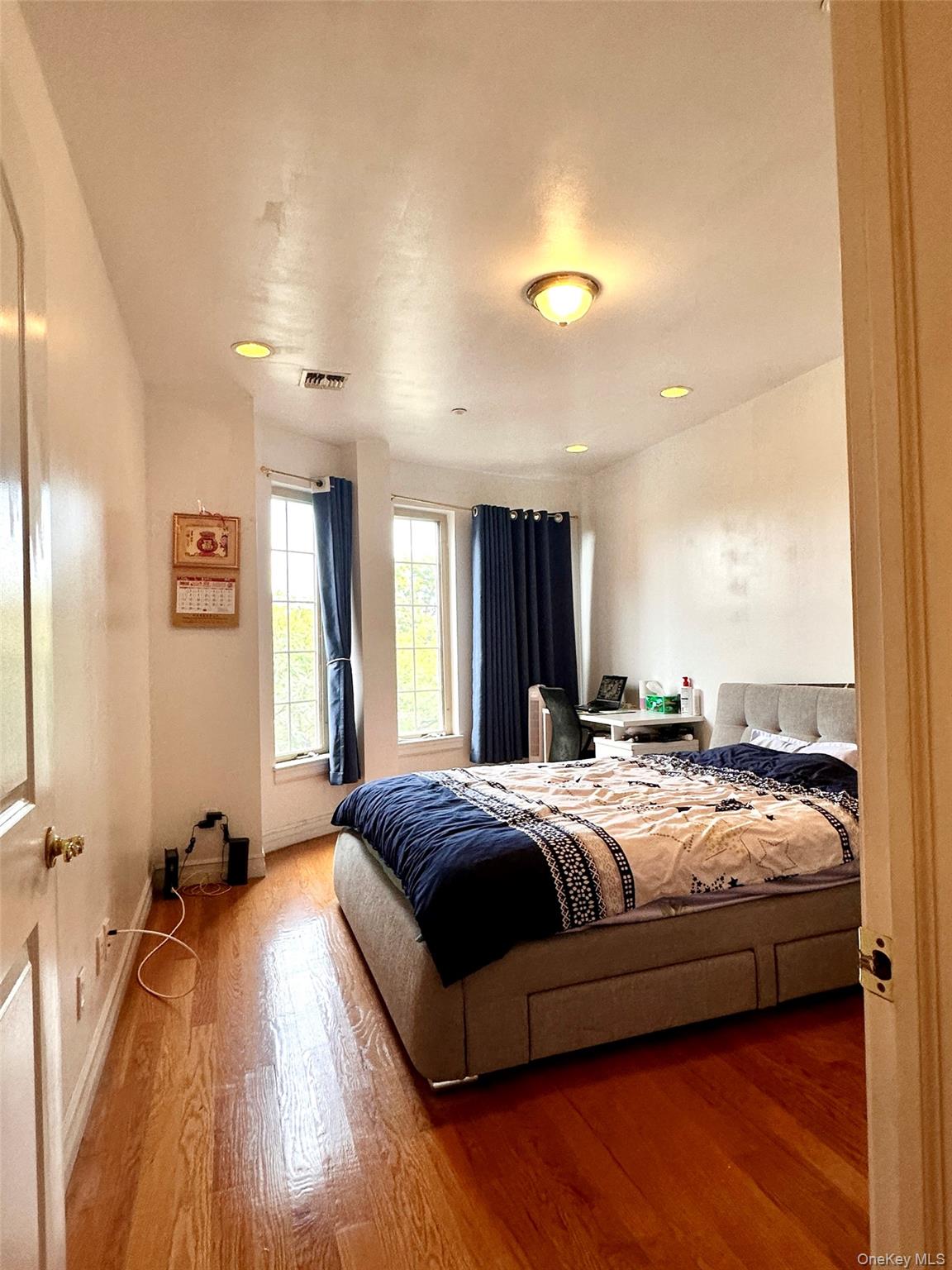 107-16 37th Avenue, Unit 4B Queens, NY 11368 - Photo 6 of 13 a spacious bedroom with a bed and wooden floor