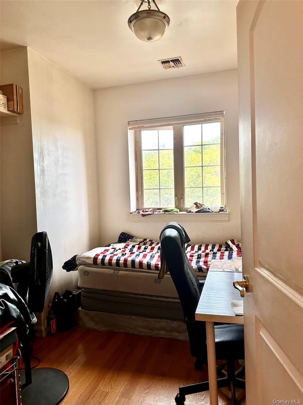 107-16 37th Avenue, Unit 4B Queens, NY 11368 - Photo 9 of 13 a bedroom with a bed and a window