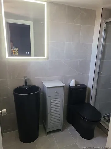 a bathroom with a sink a toilet and mirror