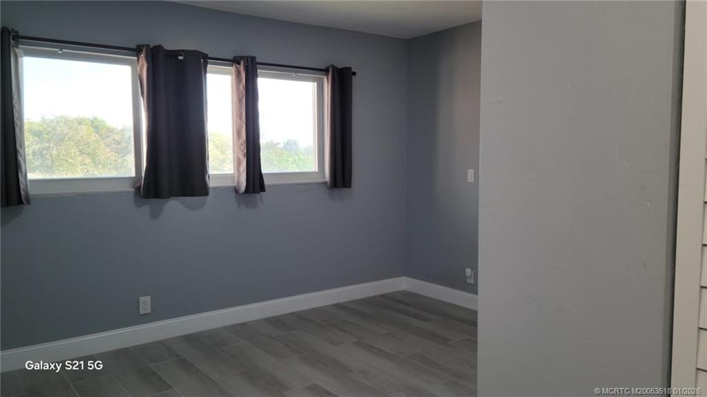 13715 Southwest 66th Street, Unit 415 Miami, FL 33183 - Photo 18 of 20 an empty room with wooden floor and windows