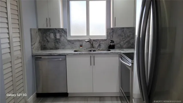 a kitchen with a sink cabinets and a window