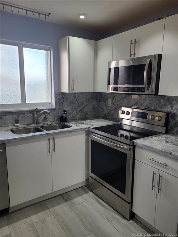 13715 Southwest 66th Street, Unit 415 Miami, FL 33183 - Photo 8 of 20 a kitchen with a stove and a microwave