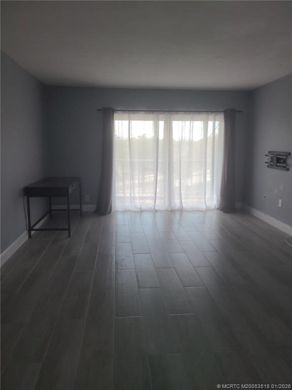 13715 Southwest 66th Street, Unit 415 Miami, FL 33183 - Photo 10 of 20 a view of an empty room with wooden floor and a window