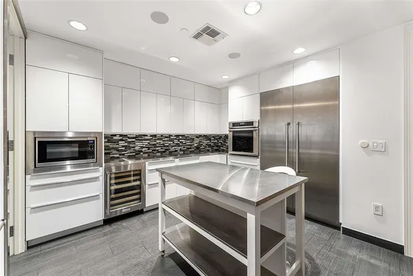 a kitchen with a table chairs refrigerator and cabinets
