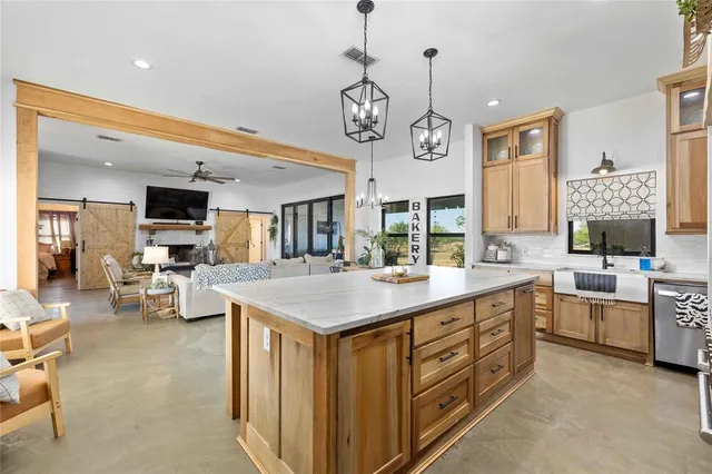 a kitchen with kitchen island a dining table and chairs