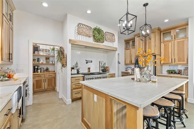 a kitchen with stainless steel appliances granite countertop a sink a stove and a wooden floors