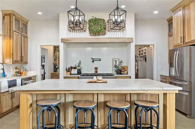 a kitchen with granite countertop a table chairs stove refrigerator and microwave